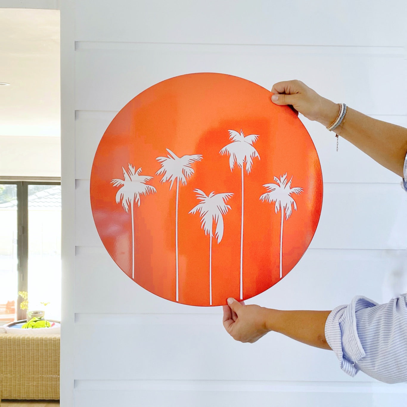 Palm Tree bright orange wall decor against white wall with breeze blocks in New Zealand. 