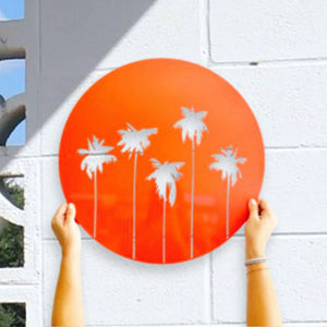 Palm Tree bright orange wall decor against white wall with breeze blocks in New Zealand. 