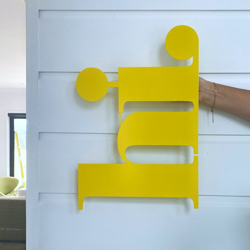 Large yellow "hi" wall sign in entrance of modern home. 