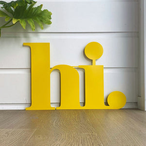 Large yellow "hi" wall sign in entrance of modern home. 